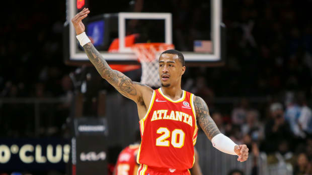 John Collins waves to the fans during a game.